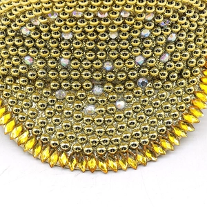 Macro detail of bridal party hat with golden beads and sparkling yellow rhinestones