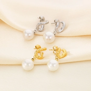 Details von eleganten Gold- und Silber-Edelstahlohrringen mit weißen Perlen