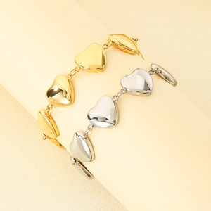 Vue détaillée de breloques en forme de cœur sur des bracelets en acier titane plaqué or 18 carats