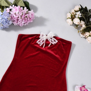 Detail of red velvet tube dress with lace bow and hanging pearl pendants