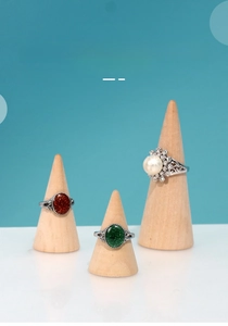 Detail of wooden cone ring holders displaying vintage rings with pearl and stones