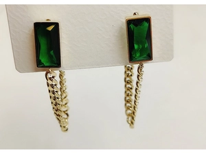 Detail showing emerald green rectangular gems with gold Cuban chain drop earrings