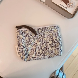 Floral cotton linen coin purse with zip closure and woven lanyard detail on desktop