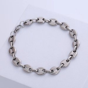 Men's silver stainless steel coffee bean link bracelet on minimalist stone display