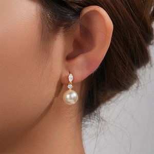 Macro shot of elegant S925 silver pearl earrings with marquise zircon stones on a model