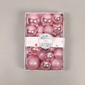 Pink Christmas ornaments in matte and glitter finishes displayed in a clear rectangular box