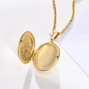 Macro detail of golden oval locket necklace showing inner floral engraving and photo space