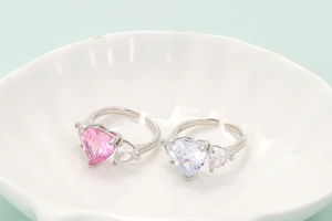 Detailed shot of pink and white heart-shaped crystal rings in a white shell dish
