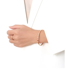Close-up of rose gold titanium steel bracelet and ring with zircon inlay on model