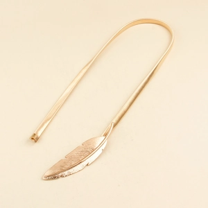 Detailed view of the golden metal leaf buckle and spring chain belt on beige background
