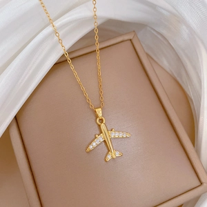 Macro shot of gold airplane pendant with shimmering rhinestones on polished O-chain