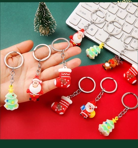Close-up of PVC Christmas keychains featuring Santa Claus and reindeer with metal rings