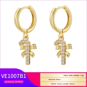 Detail of brass Christmas candy cane earrings with cubic zirconia and bow decoration