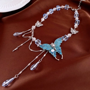 Detailed view of butterfly pendant with silver tassels and blue crystal bead necklace