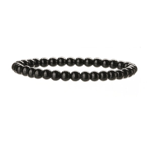 Vue macro de perles de pierre noire polie de 6mm sur un bracelet élastique