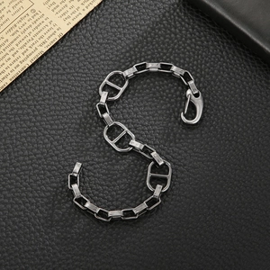 Industrial style silver chain bracelet with oval links on black leather background