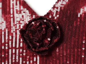Macro shot of sequined wine red fabric with a detailed 3D sequin flower embellishment