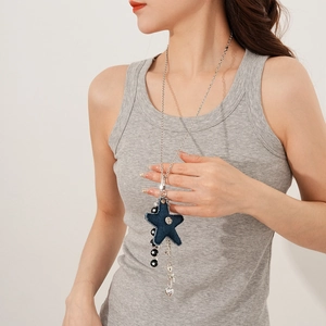 Detail of titanium steel necklace with blue denim star pendant and silver tassels