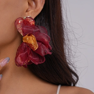 Détail d'une grande boucle d'oreille fleur en mousseline rouge foncé avec touches dorées