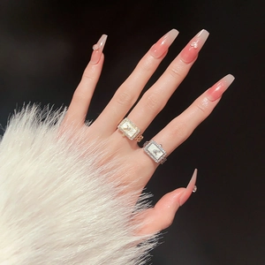 Detail of square watch-style rings with crystals and chain bands on hand