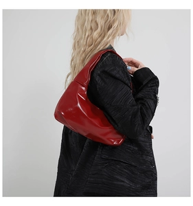 Detail der roten Hobo-Tasche aus glänzendem Ölwachs-Leder getragen am Model-Anzug