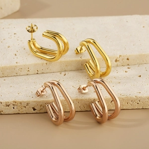 Boucles d'oreilles minimalistes en U double couche, dorées et or rose sur marbre