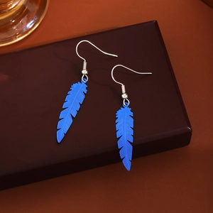 Bohemian blue feather drop earrings with intricate metal textures on a dark background