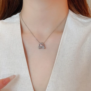 Close-up of heart-shaped pink crystal pumpkin carriage pendant with sparkling diamonds