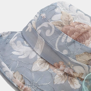Macro shot of light blue sun hat with detailed floral embroidery and organza texture