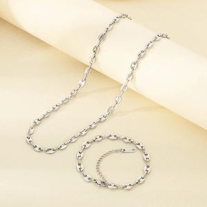 Vue détaillée d'un ensemble collier et bracelet en acier poli maille grain de café