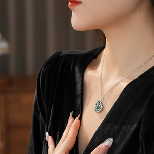 Close-up of emerald zircon gourd pendant necklace on model with silver chain