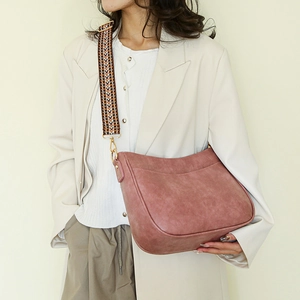 Dettaglio della borsa tote rosa con tracolla geometrica intrecciata e finiture in metallo oro