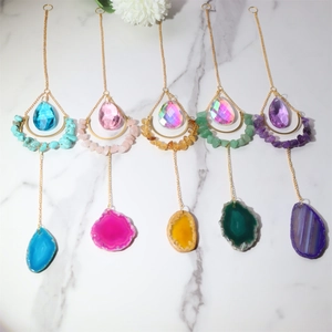 Detail of five moon-shaped suncatchers with natural agate slices and crystal prisms