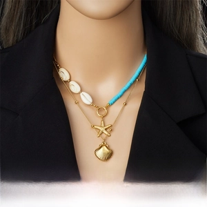 Detail of double-layer gold necklace with starfish, scallop pendants and blue shell beads