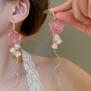 Detail view of floral tassel earrings with pink fabric petals and white faux pearls