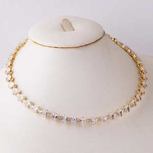 Detailed view of elegant gold-tone necklace with heart and drop zircon on mannequin