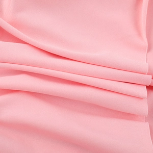 Gros plan détaillé montrant la texture tricotée rose doux et le drapé fluide de la robe en V