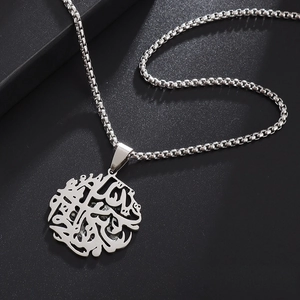 Macro detail of stainless steel box chain with an Islamic calligraphy hollow pendant