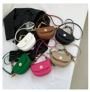 Flat lay of multiple colorful saddle bags with metal chain and silk scarf handles