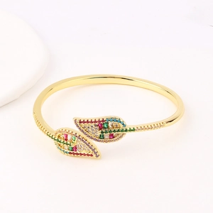 Gold plated open leaf bangle with vibrant colorful zircon stones on white background