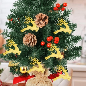 Glittery gold reindeer ornaments hanging on a small decorated Christmas tree with pine cones