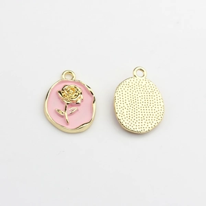 Detail of pink enamel oval pendant with golden 3D rose and textured metal back