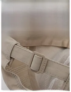 Dettaglio della fibbia regolabile e mesh traspirante su un cappellino sportivo color kaki