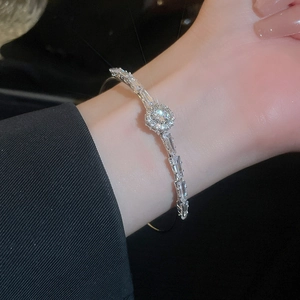 Macro detail of luxury silver bangle featuring sparkling zircon geometric crystals on wrist