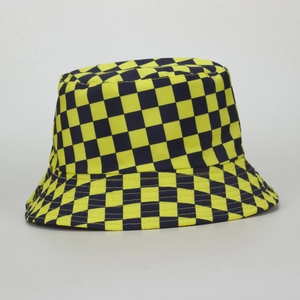 Détail du motif à damier jaune et noir sur le bob en toile de coton pour un look urbain