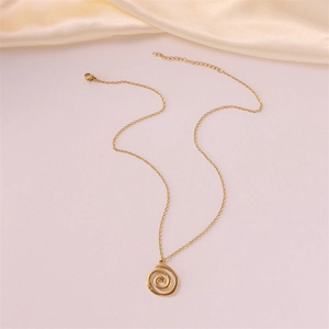 Minimalist gold spiral pendant necklace with a fine O-chain on elegant cream silk background