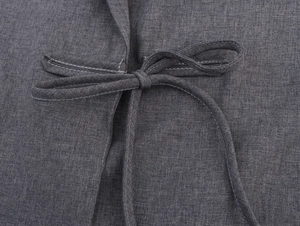 Detail view of grey linen blazer featuring a fabric waist tie and precise white stitching