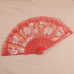 Détail d'éventail en dentelle rouge avec motifs de roses dorées et monture en plastique