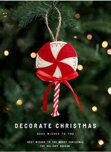 Close-up of felt lollipop Christmas ornament with red bow on a festive tree branch