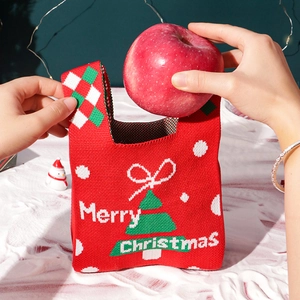Festive red knitted Christmas gift bag with tree pattern for holiday apples